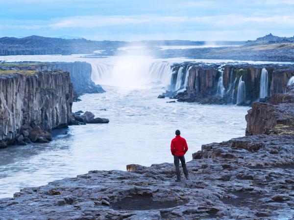 Man admiring Selfoss waterfall in the distance