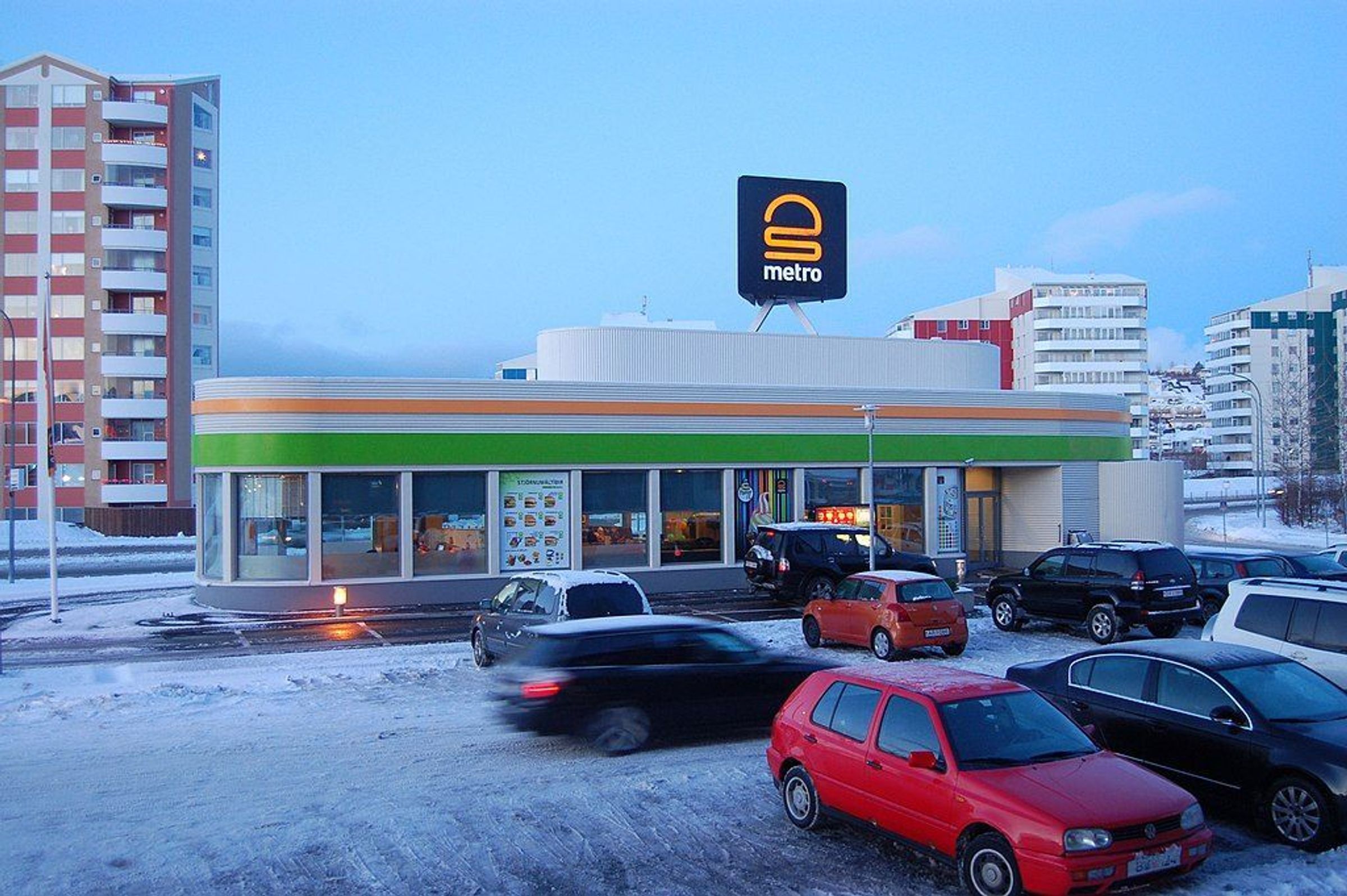 a lot of cars are parked in front of a metro store .