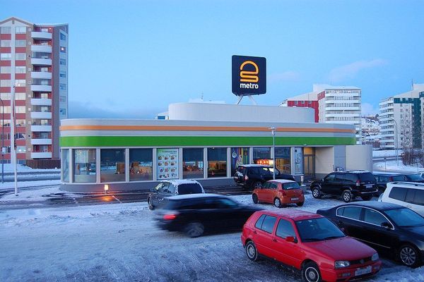 a lot of cars are parked in front of a metro store .