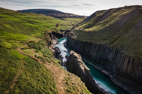 una vista aérea de un río que fluye a través de un cañón entre dos montañas.