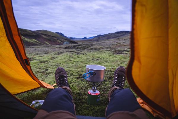 a person is sitting in a tent with a cup of coffee .
