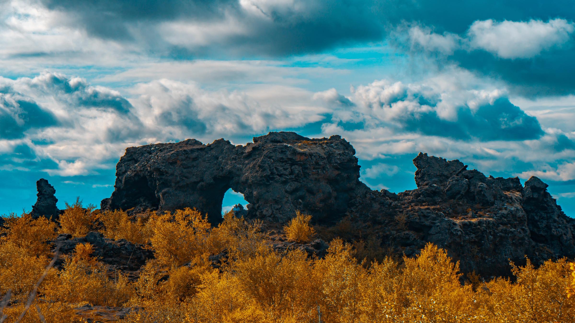 an arch rock with autumn colored vegetation