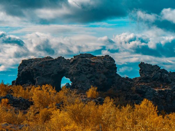 an arch rock with autumn colored vegetation