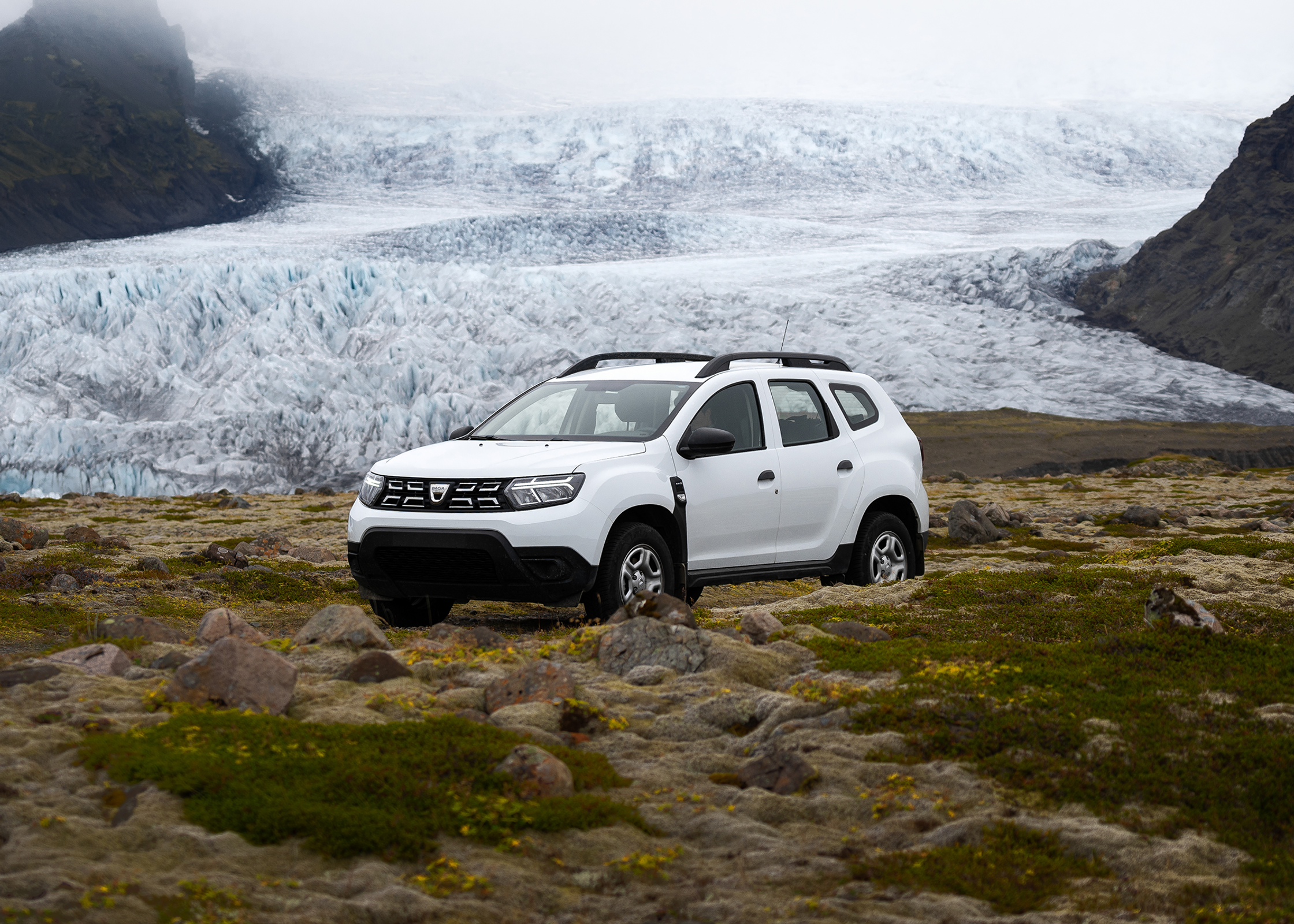 un duster blanco está aparcado frente a un glaciar