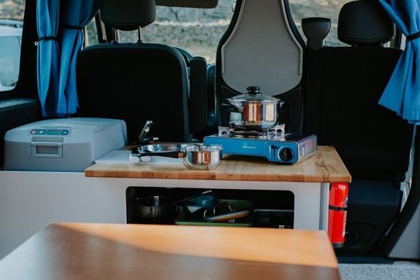 there is a stove and a table in the back of a van in iceland.