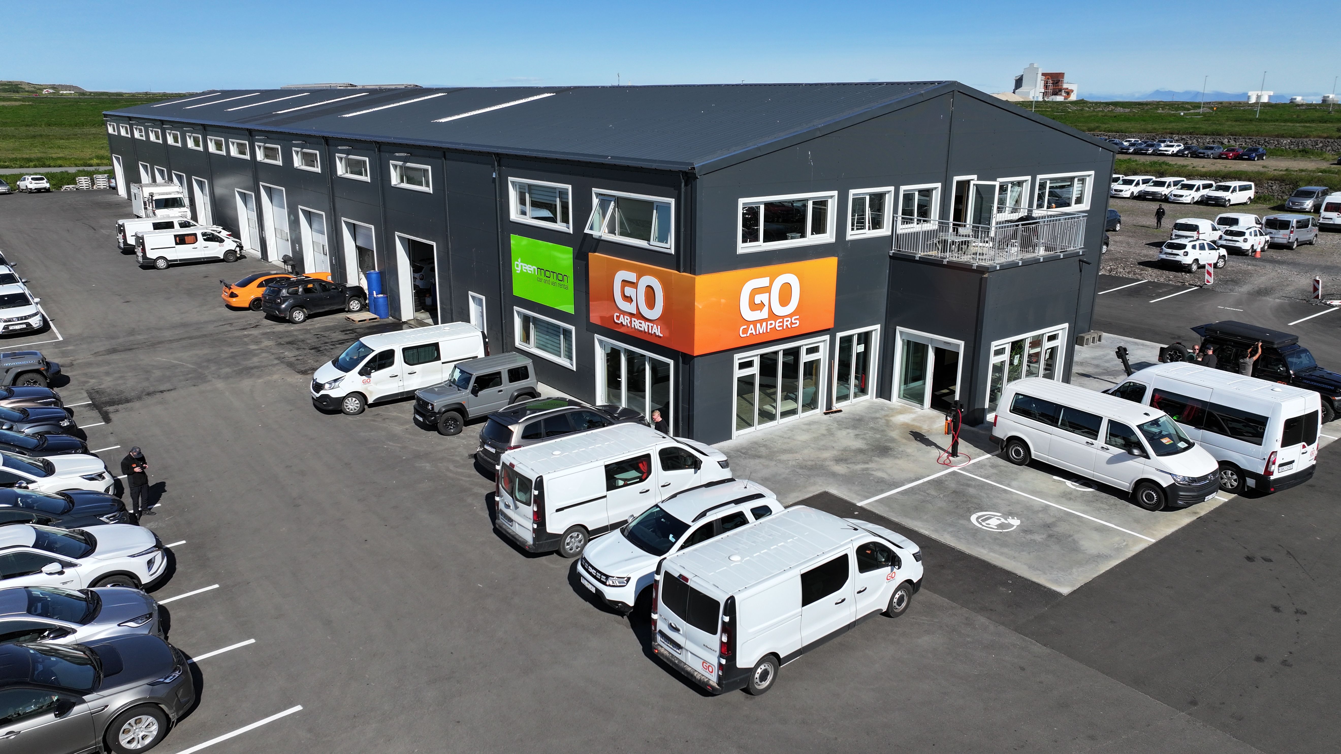 a large building with a lot of cars parked in front of it .
