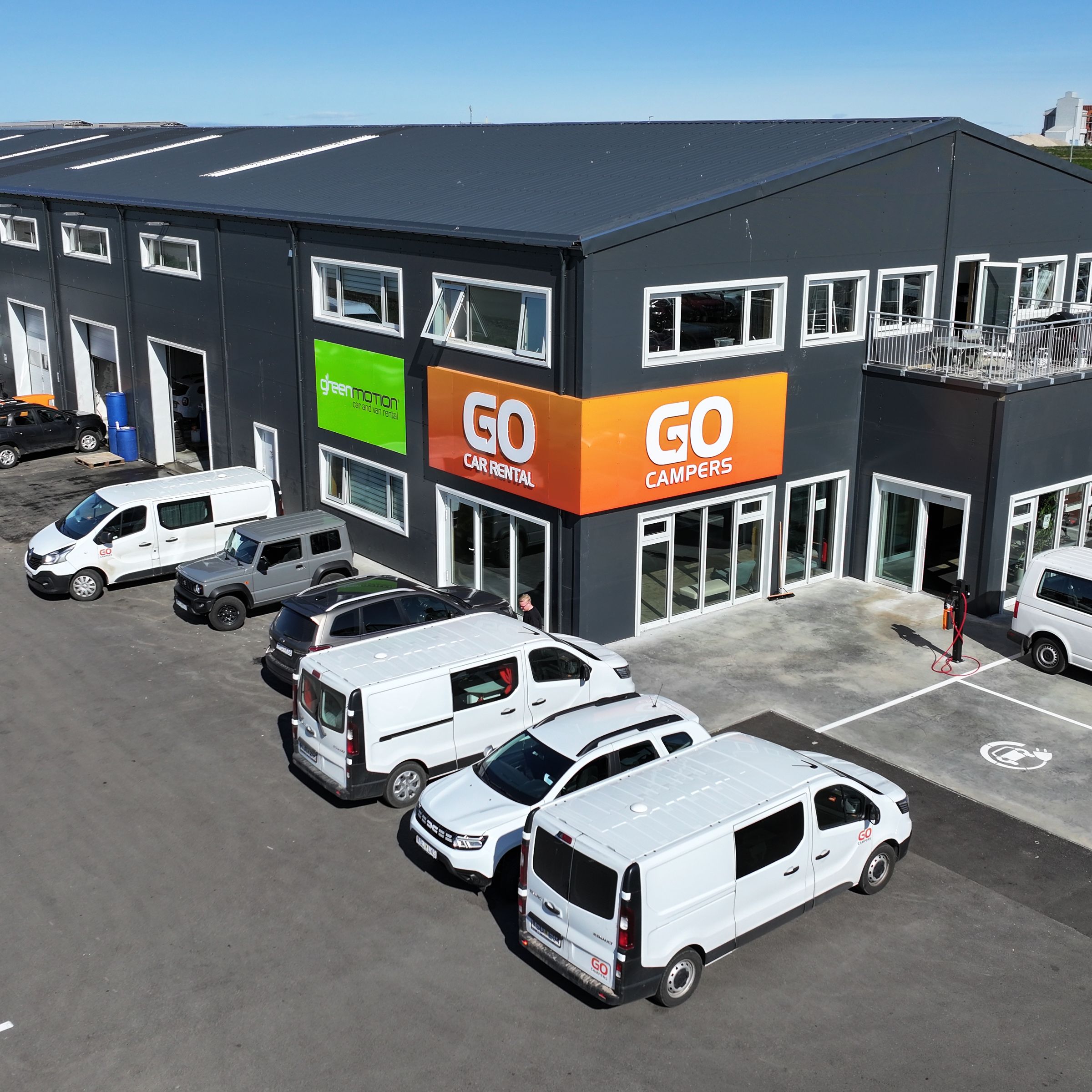 a large building with a lot of cars parked in front of it .