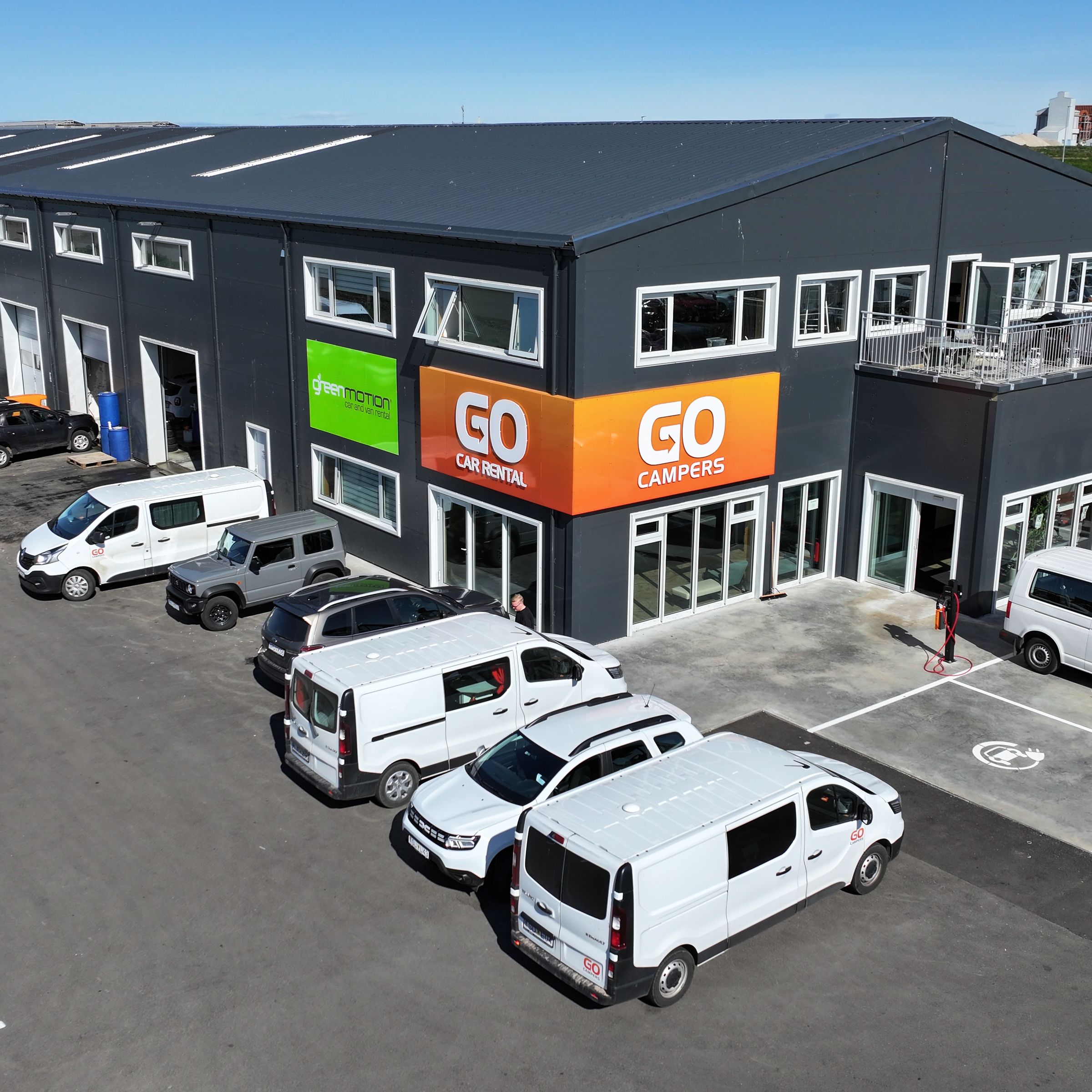a large building with a lot of cars parked in front of it .