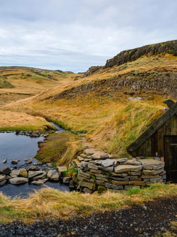 pequeña piscina de aguas termales al lado de una pequeña casa de madera