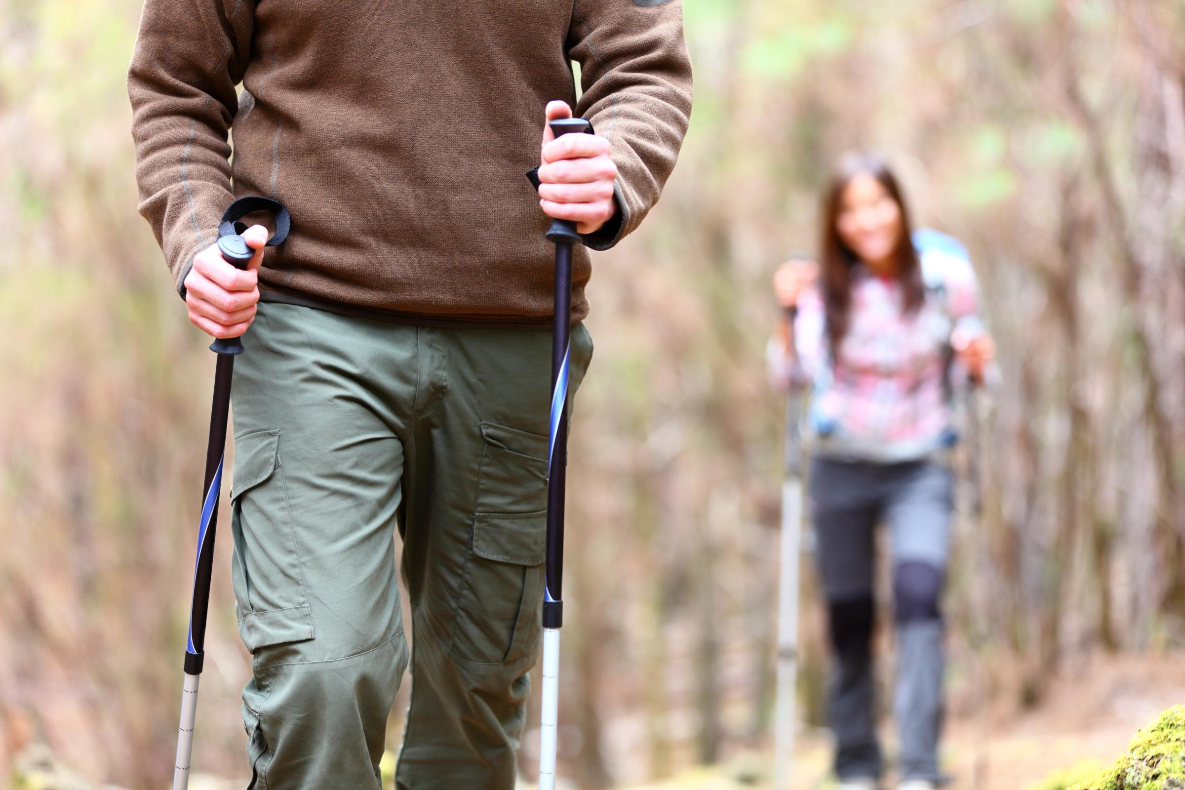 a man and a woman are hiking in the woods .