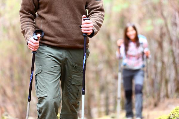 a man and a woman are hiking in the woods .