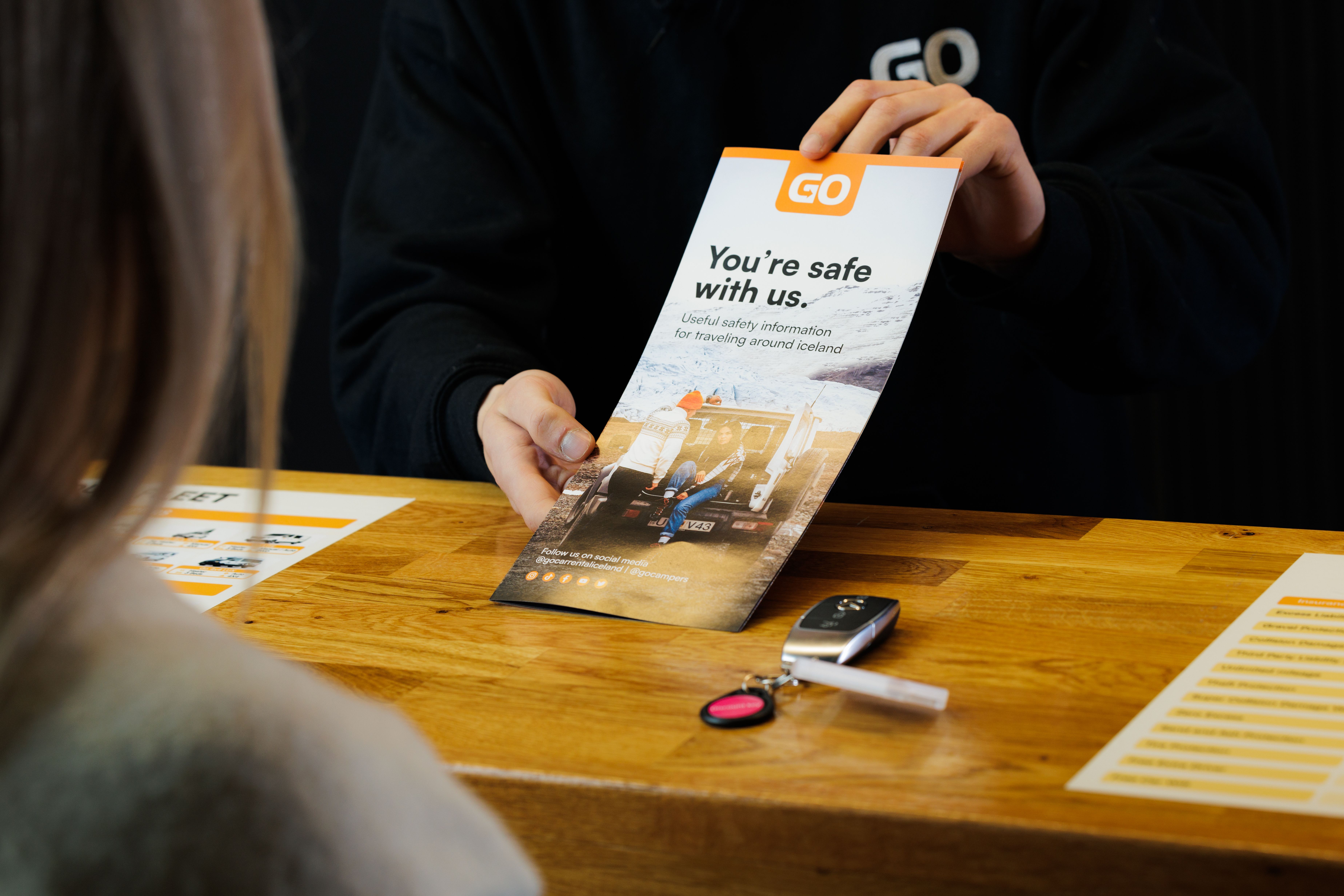 a man is holding a brochure in front of a woman at a table .
