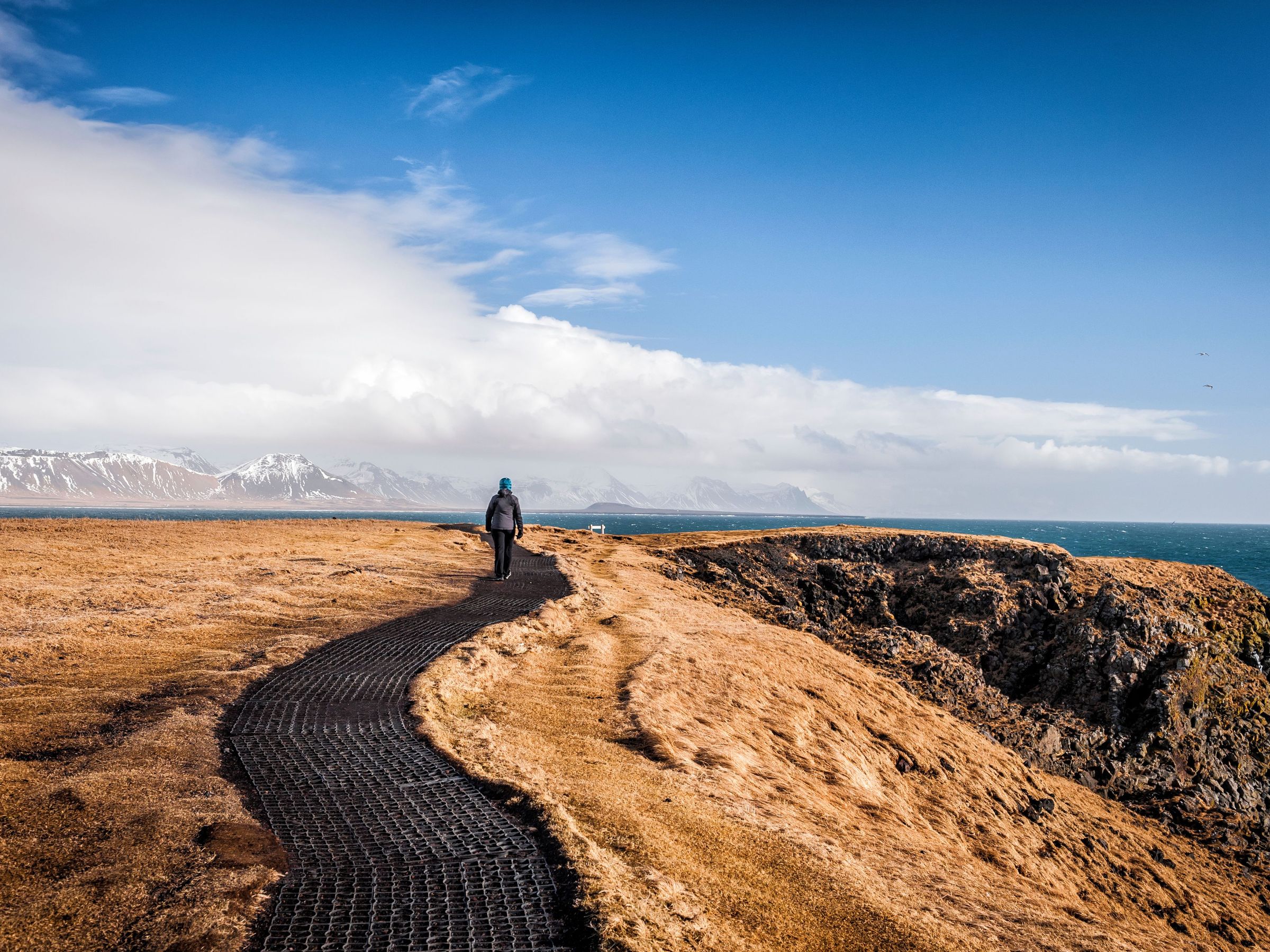 Hombre caminando por el paseo que une Hellnar y Arnarstapi