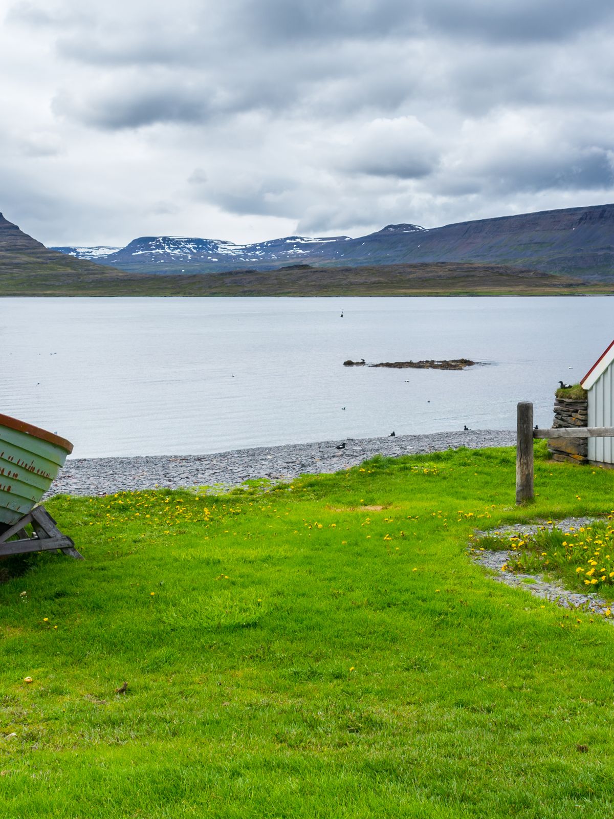 hay un barco y una casa en la orilla de un lago .
