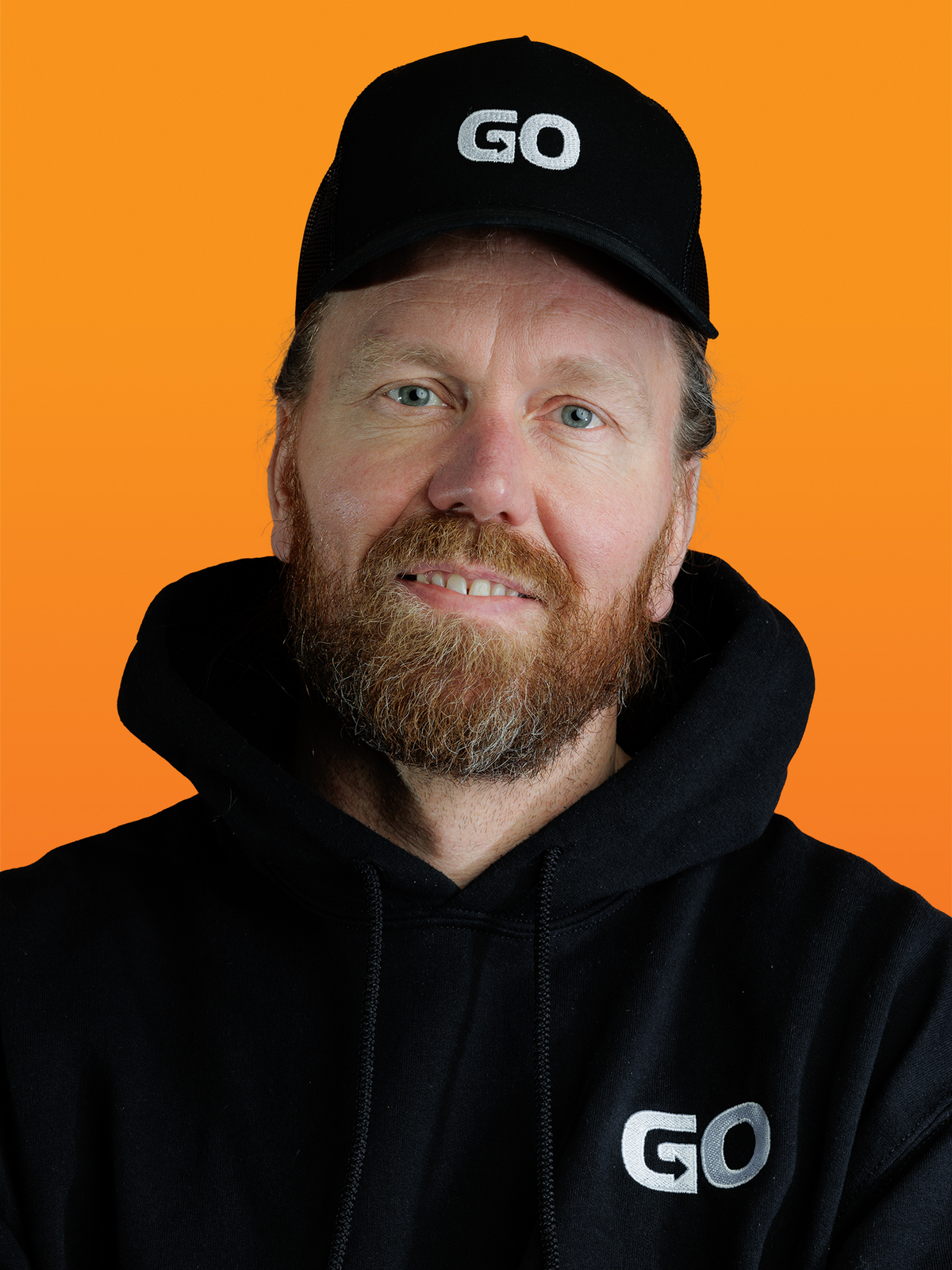 a man with a beard wearing a black hat that says go