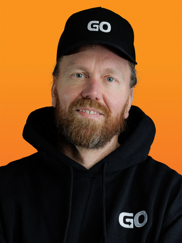 Hombre con barba y una gorra en la que pone go.