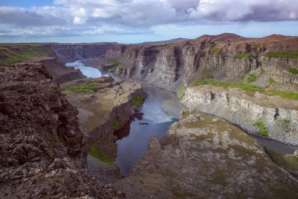 an aerial view of a canyon with a river running through it, at hólmatungur in Iceland.