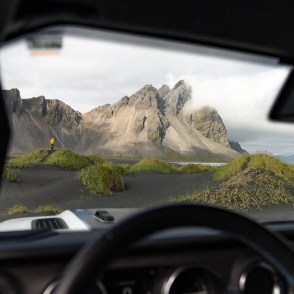 Mujer sentada en la parte de atrás de una furgoneta con una taza de café.