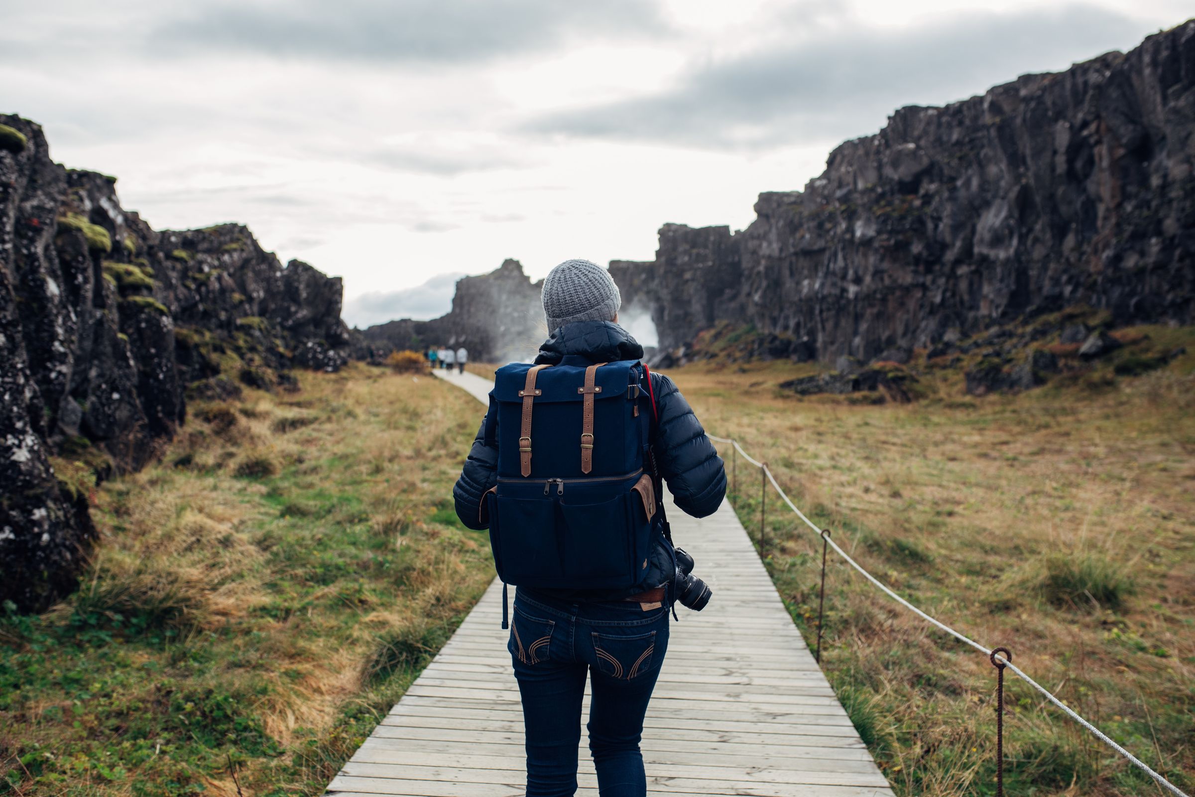 a person with a backpack is walking down a wooden path in iceland.