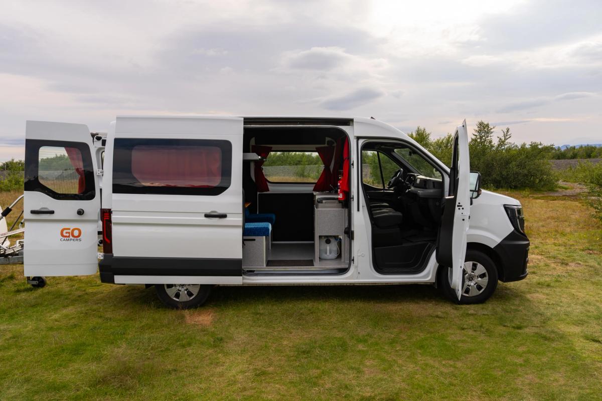 A 5 person large campervan parked on grass with all doors open, camper rental Iceland