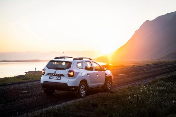 Dacia Duster Rental car Iceland White 4x4 Dacia Duster rental car parked in Iceland while watching the sunset