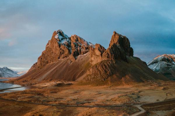 an aerial view of a mountain range with a dirt road leading to it .