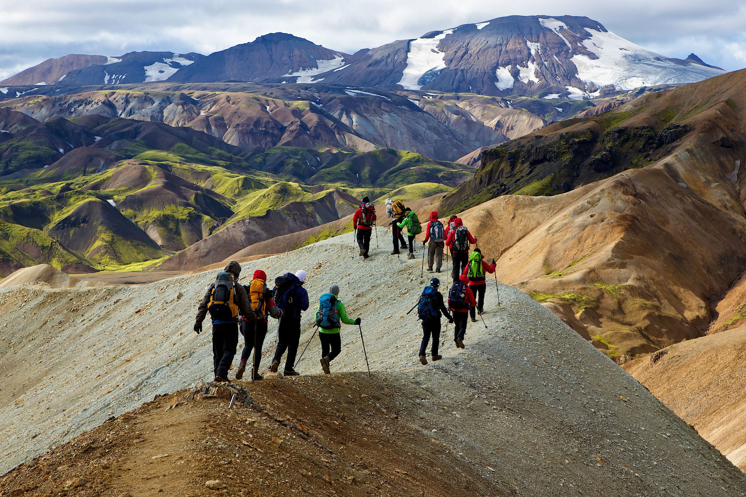 Grupo de personas haciendo caminando por la cresta de una montaña