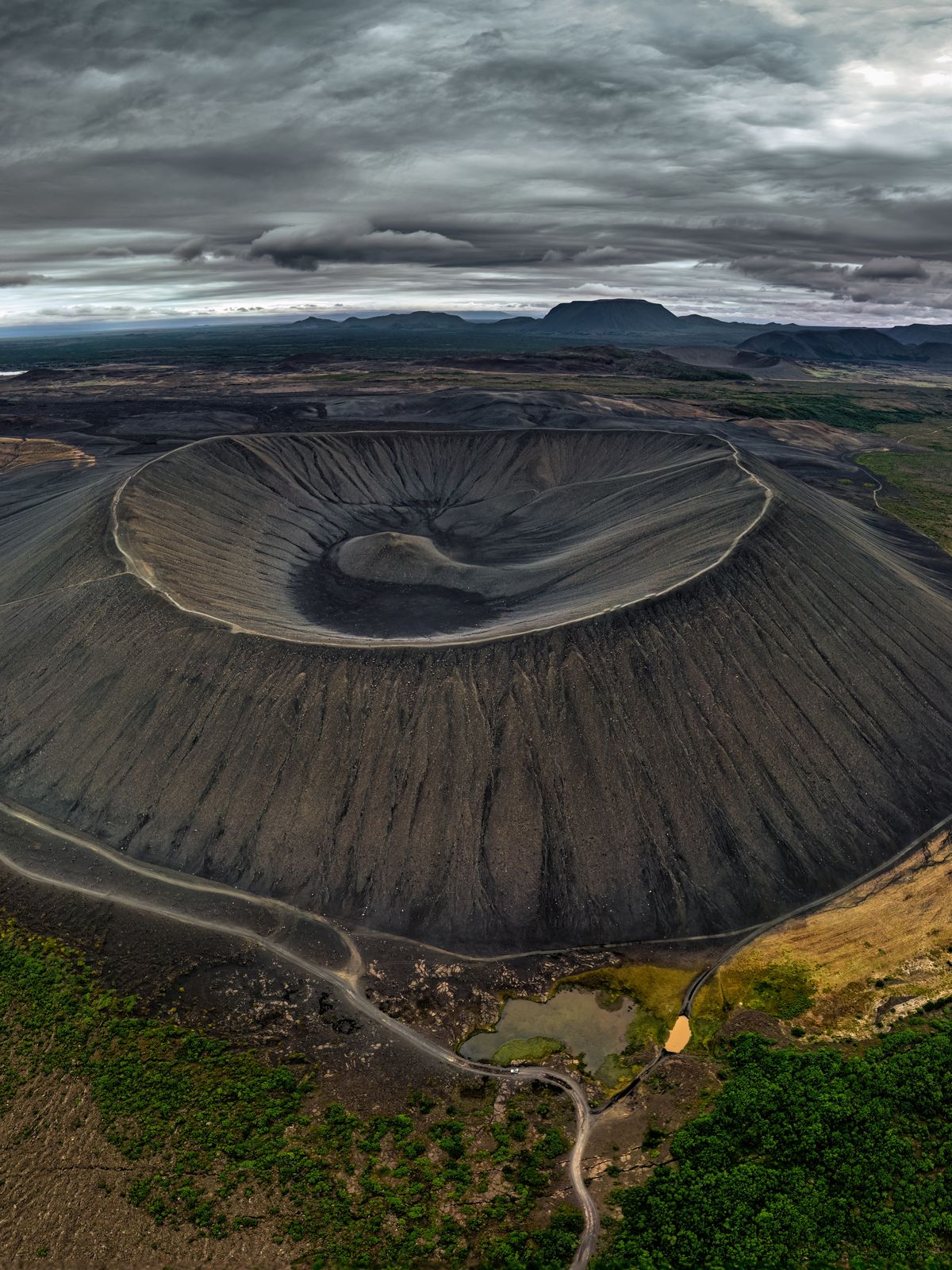 an aerial view of a volcano surrounded by trees and mountains .