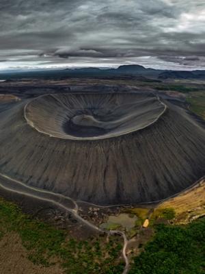 an aerial view of a volcano surrounded by trees and mountains .