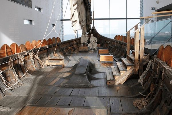 the inside of a boat with a statue of a man on it at Viking world in keflavík iceland.