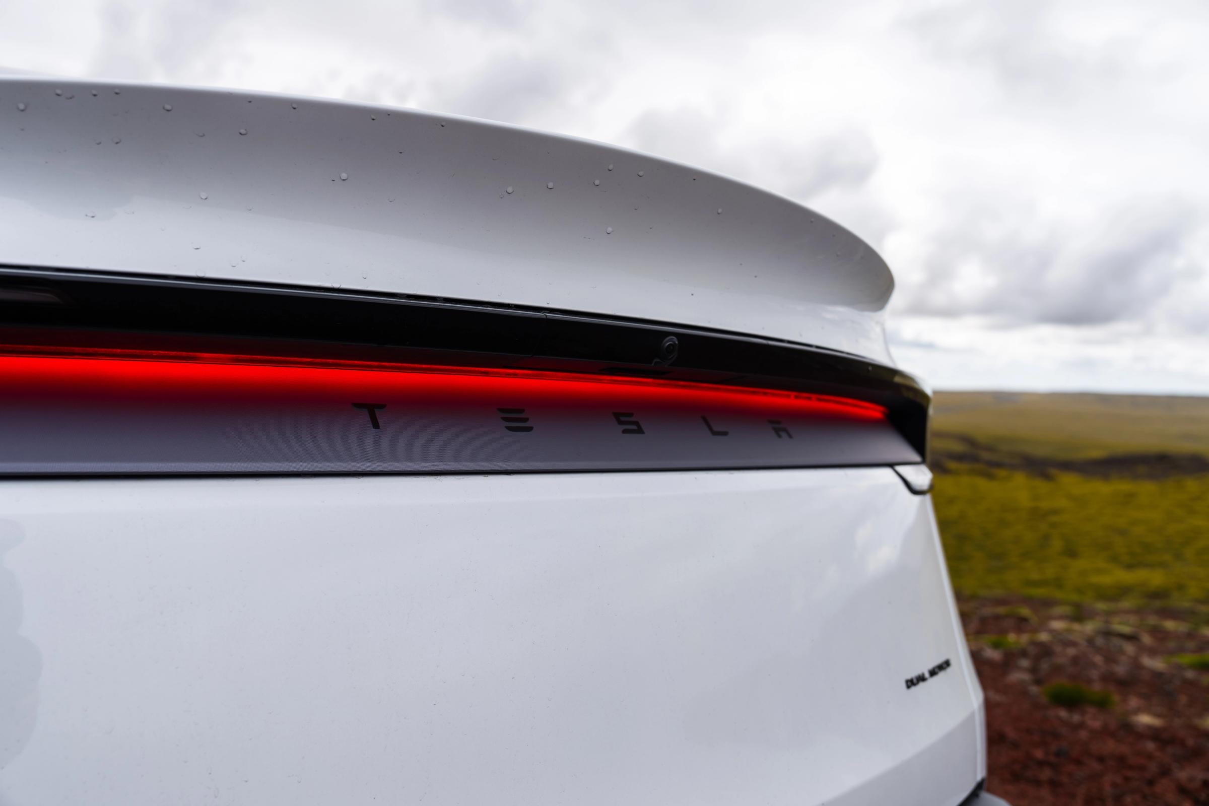 Detalle del piloto trasero y el emblema de un Tesla Model Y, coche eléctrico de doble motor de alquiler en Islandia