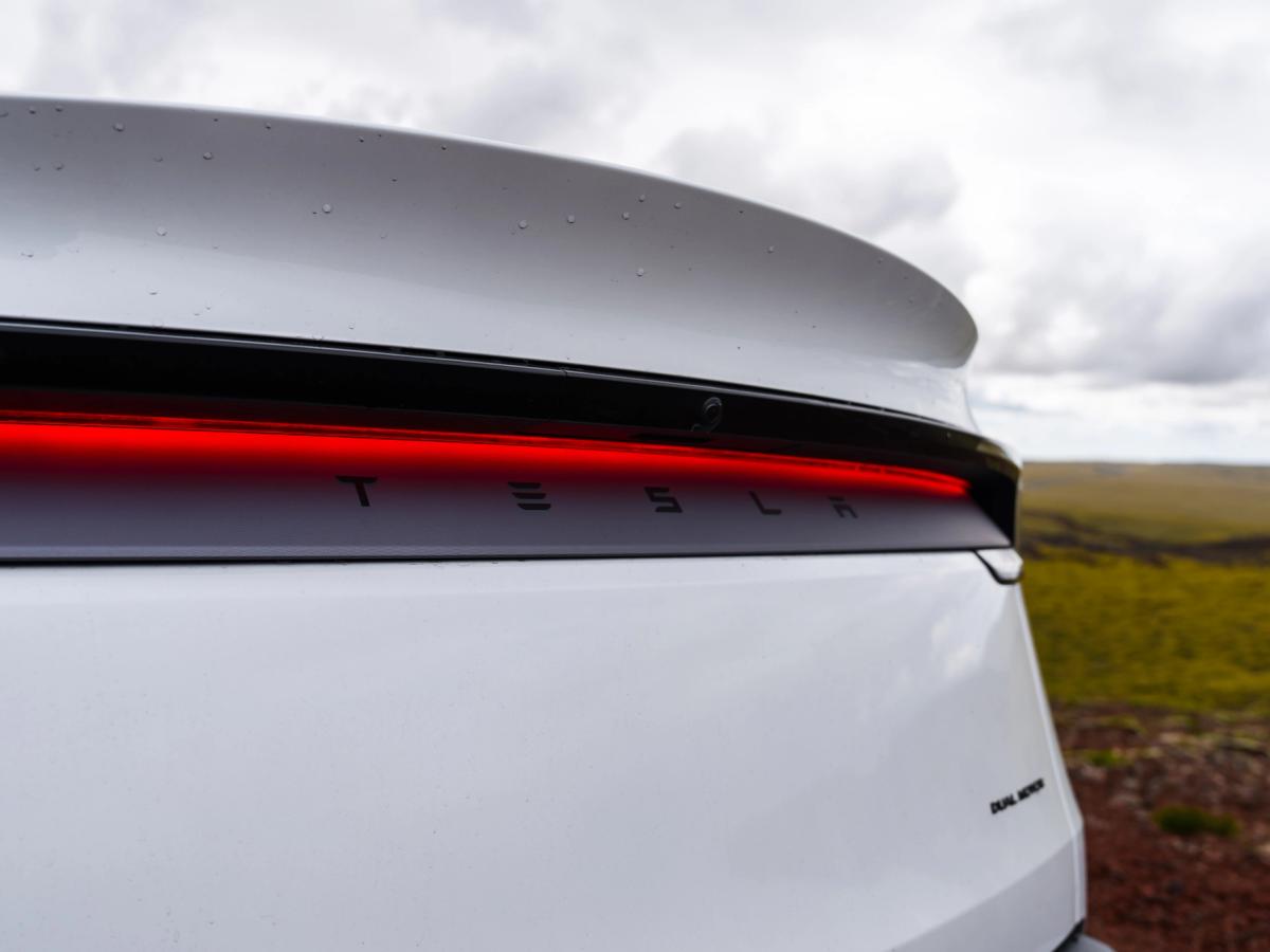 Primer plano del piloto trasero y el emblema Detalle del piloto trasero y el emblema de un Tesla Model Y, coche eléctrico de doble motor de alquiler en Islandia