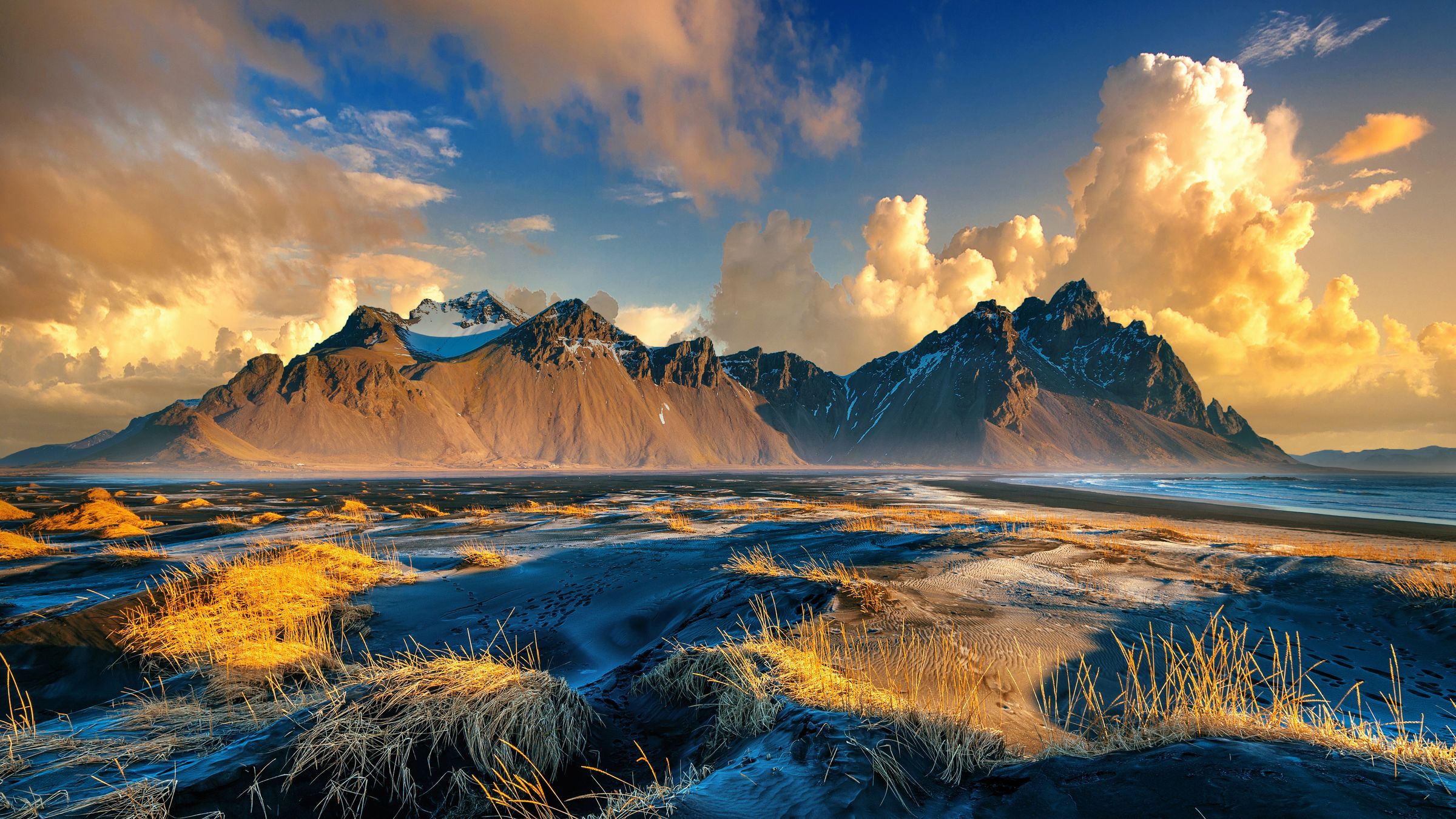 Il y a des montagnes en arrière-plan et une rivière au premier plan à Vestrahorn à Stokksnes, en Islande.