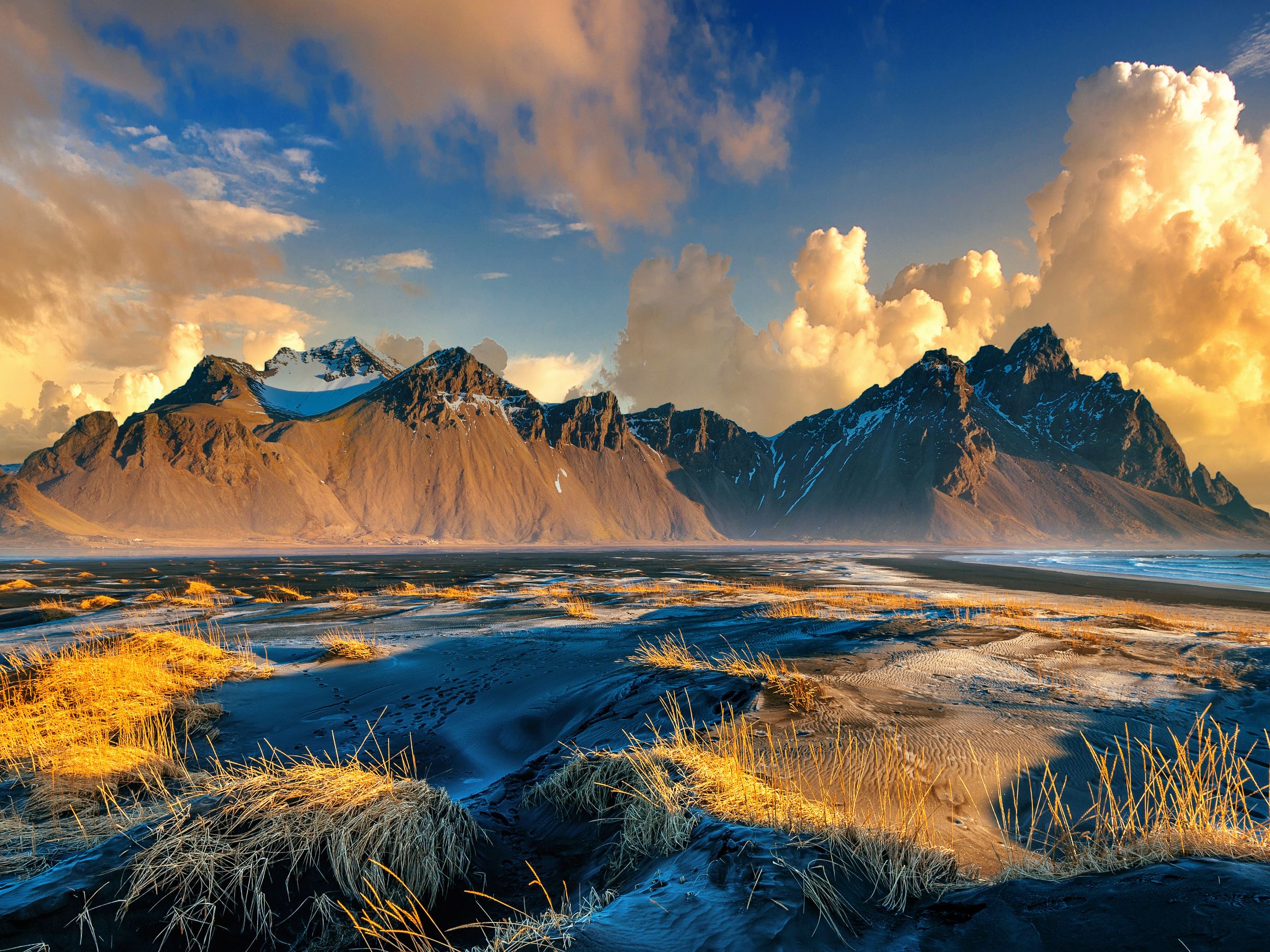 Il y a des montagnes en arrière-plan et une rivière au premier plan à Vestrahorn à Stokksnes, en Islande.