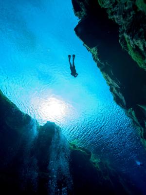 a scuba diver is swimming through a cave in the ocean