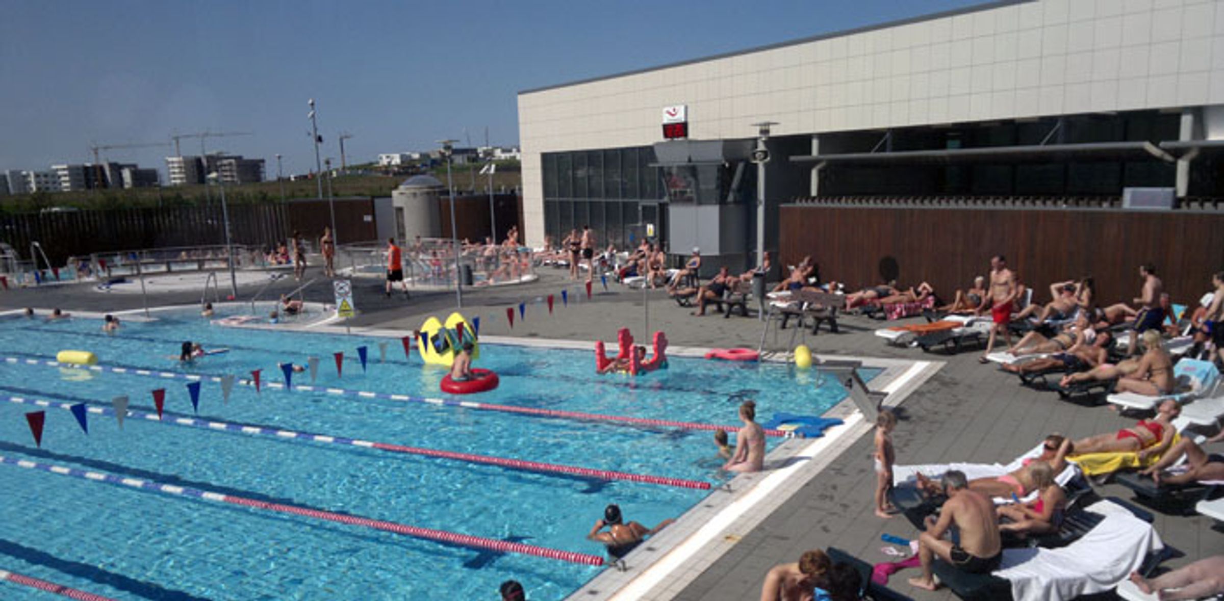 a group of people are swimming in a large swimming pool .