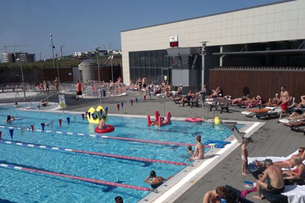 a group of people are swimming in a large swimming pool .