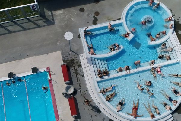 an aerial view of a swimming pool filled with people .