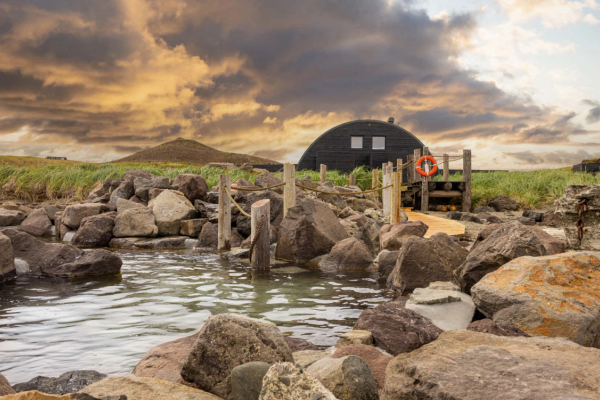 Hvammsvik Hot Springs, Iceland a life preserver is attached to a wooden bridge over a body of water