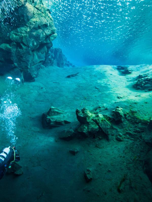 a scuba diver is swimming in the Silfra fissure in Iceland