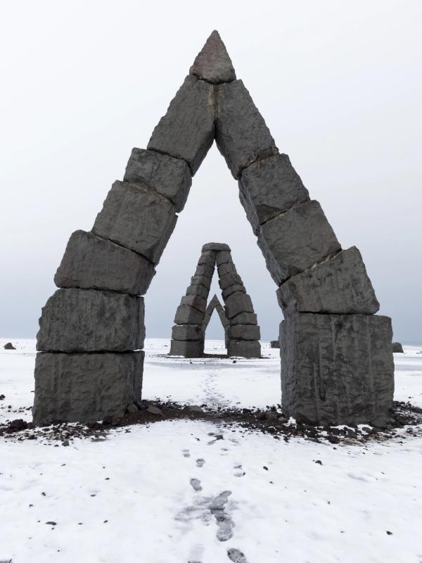 estructuras de piedra que forman arcos puntiagudos en un campo cubierto de nieve