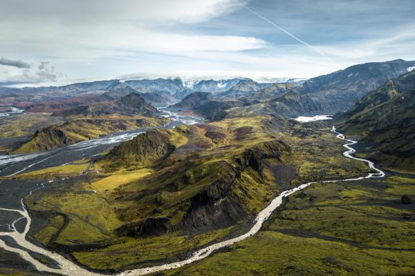 an aerial view of a river running through a valley surrounded by mountains .