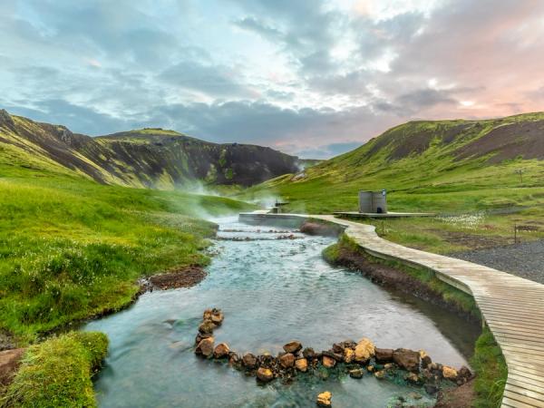 a geothermal river between green hills