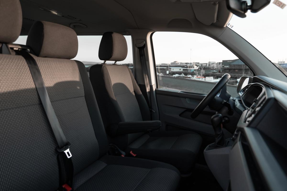 Vordersitze und manuelle Gangschaltung eines Volkswagen Caravelle mit Armaturenbrett und Blick auf den Hafen
