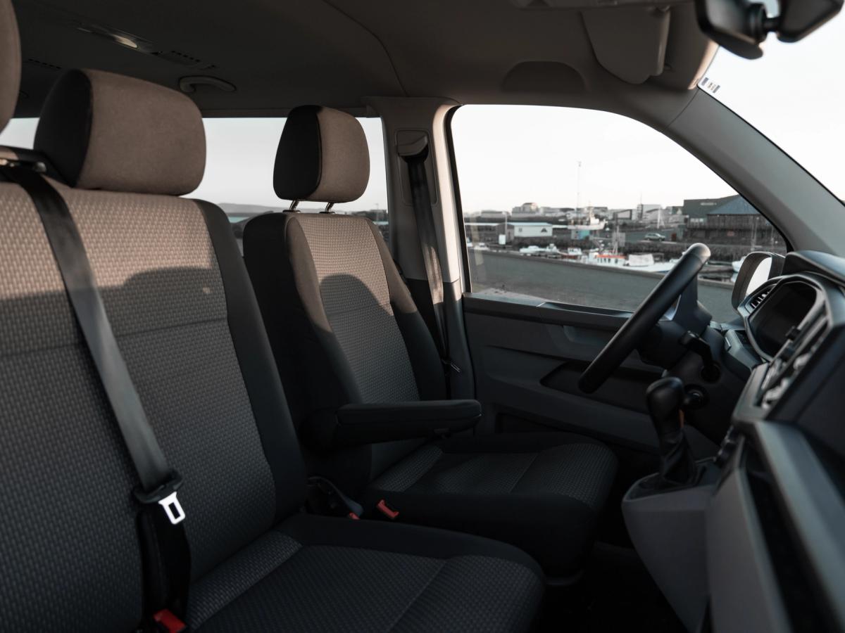 Blick in den vorderen Innenraum des Volkswagen Caravelle Vordersitze und manuelle Gangschaltung eines Volkswagen Caravelle mit Armaturenbrett und Blick auf den Hafen