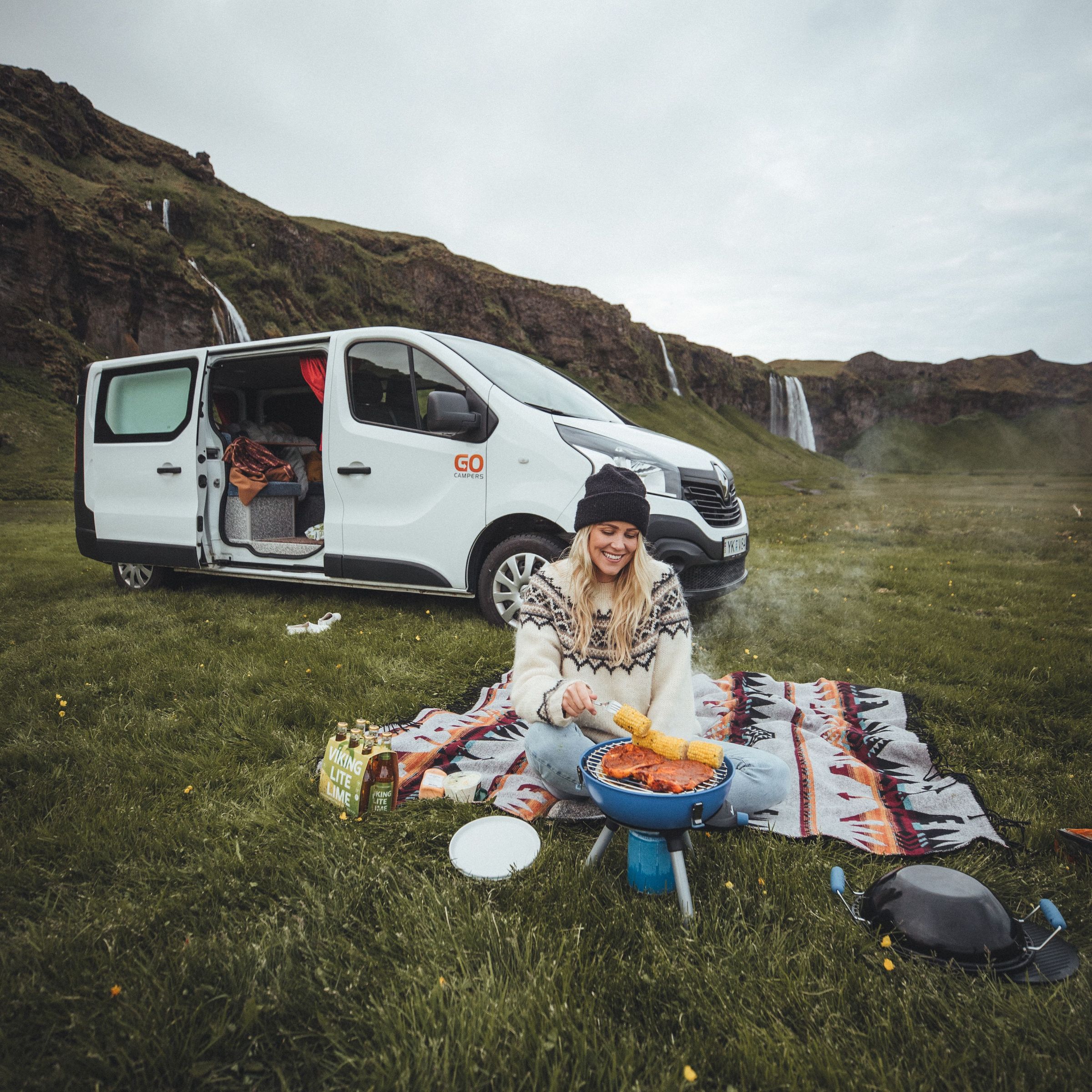 Girl camping and cooking food outside of her car rental in Iceland