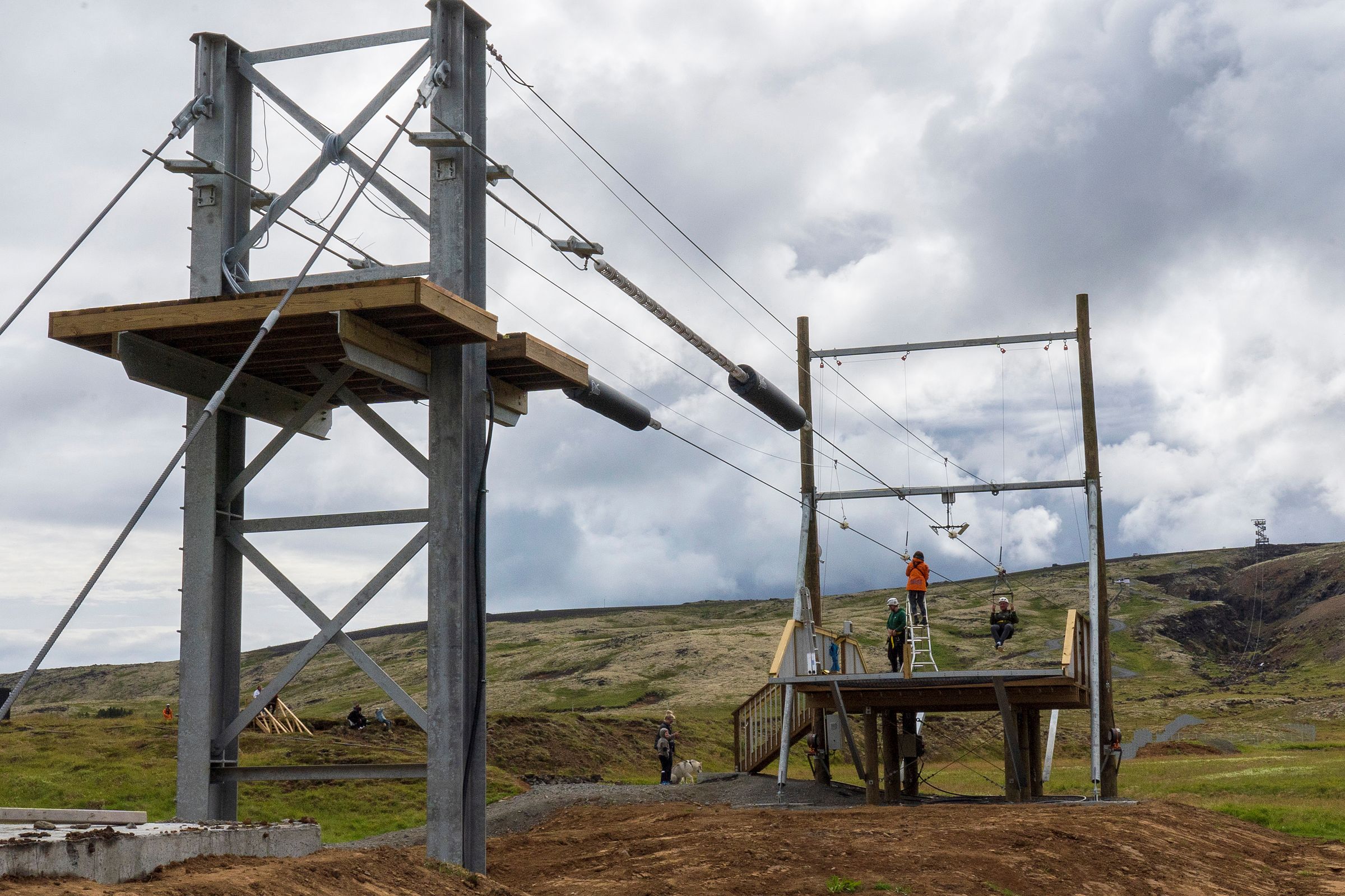 a group of people are standing on top of a wooden platform .