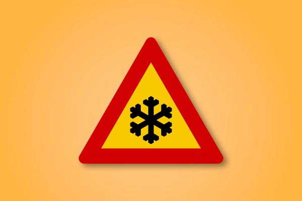 a yellow and red triangle sign with a snowflake on it .