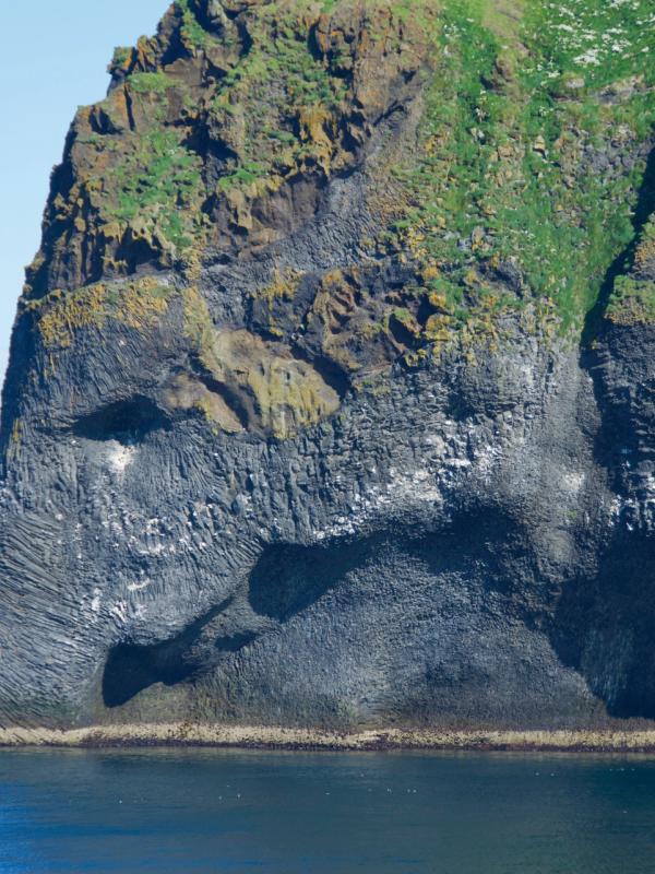 a large rock formation in the middle of the ocean .