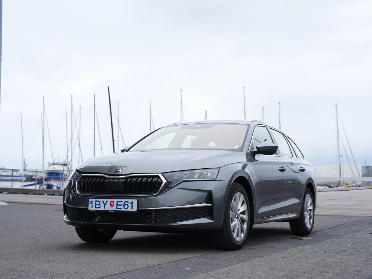 Octavia langbakur með útsýni yfir höfnina Skoda Octavia-stationbíll séður á ská að framan, lagt við höfn með seglbáta í bakgrunni